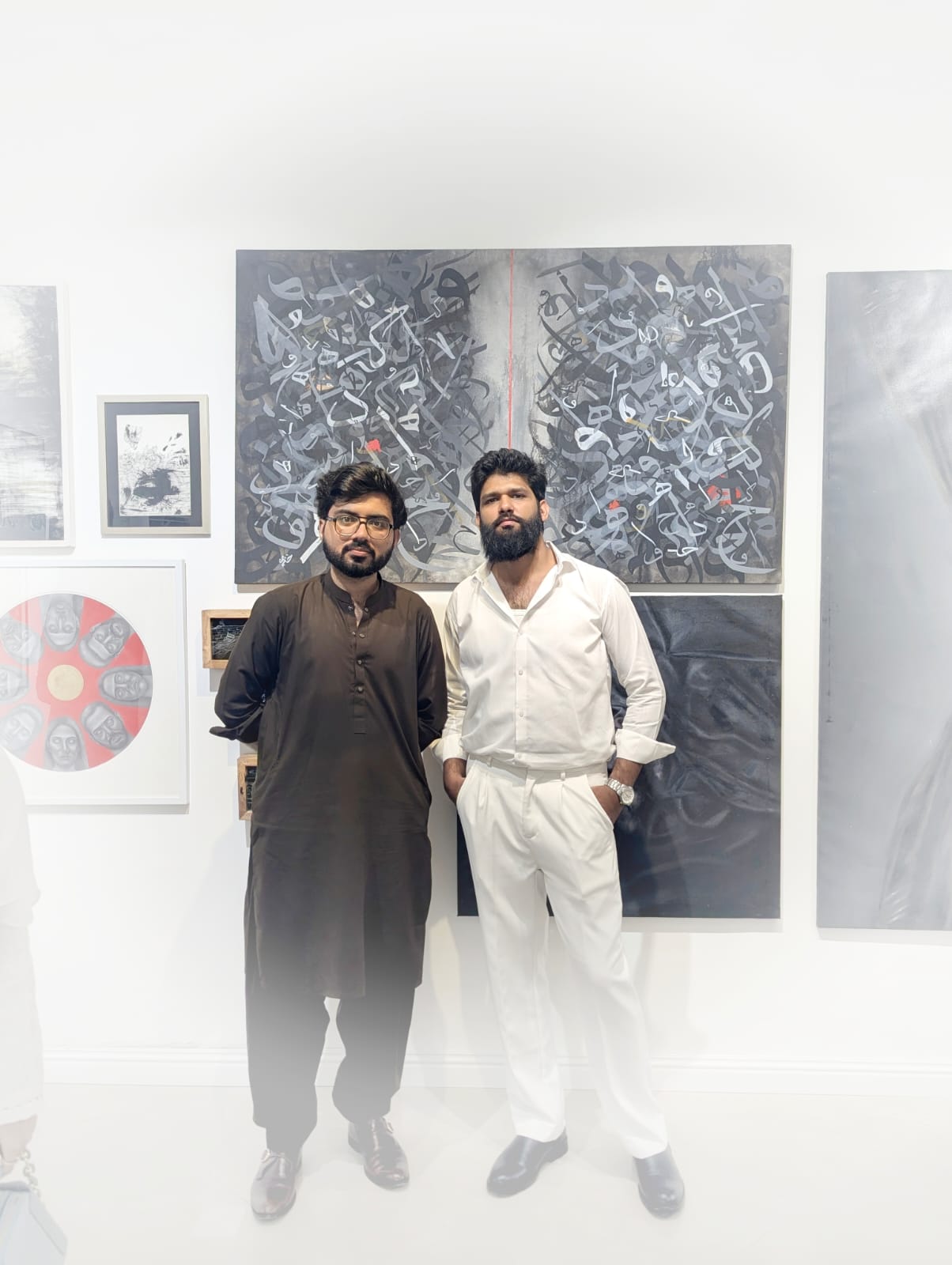 Khuzaima Ayaz and a visitor standing in front of the artist's work