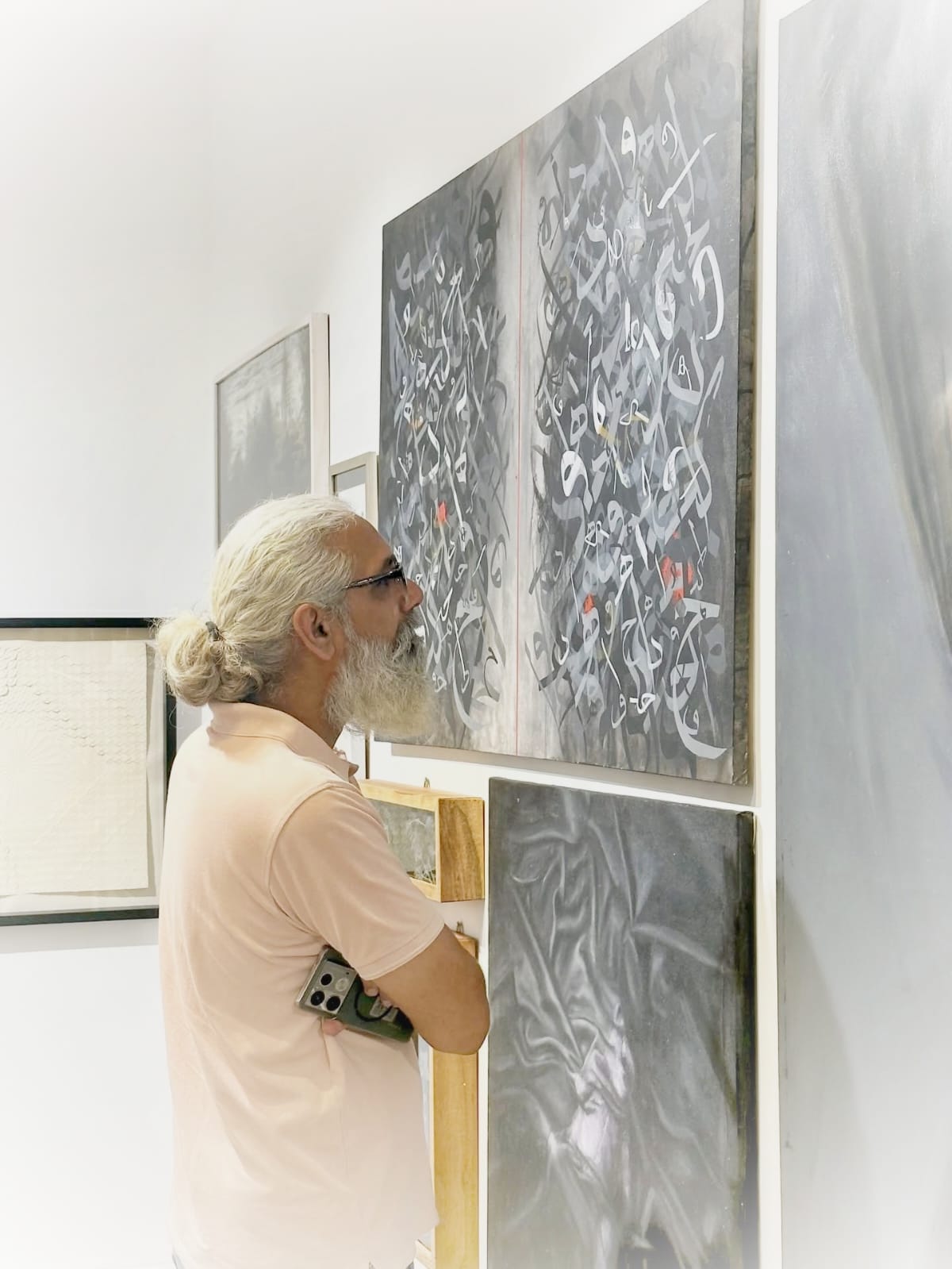 A visitor viewing Khuzaima Ayaz's calligraphic work at The Summer Show 2026